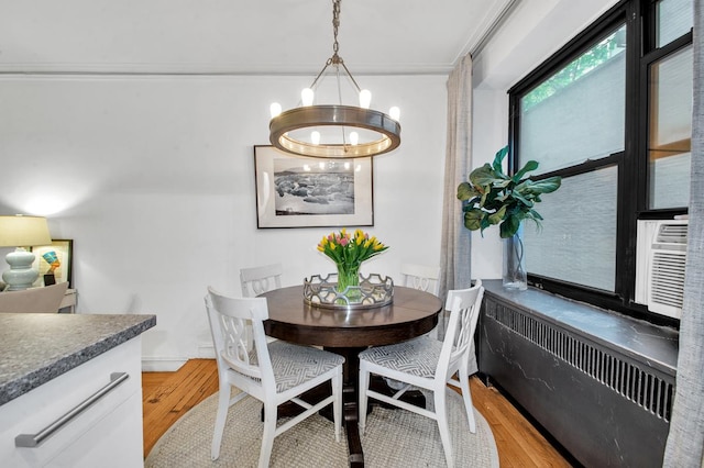 222 E 35th St Unit 1-E, New York City, NY 10016 - dining area with light wood finished floors, radiator heating unit, a chandelier, and ornamental molding