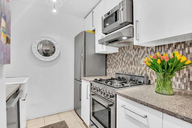 222 E 35th St Unit 1-E, New York City, NY 10016 - kitchen with stainless steel appliances, range hood, light tile patterned floors, white cabinets, and backsplash