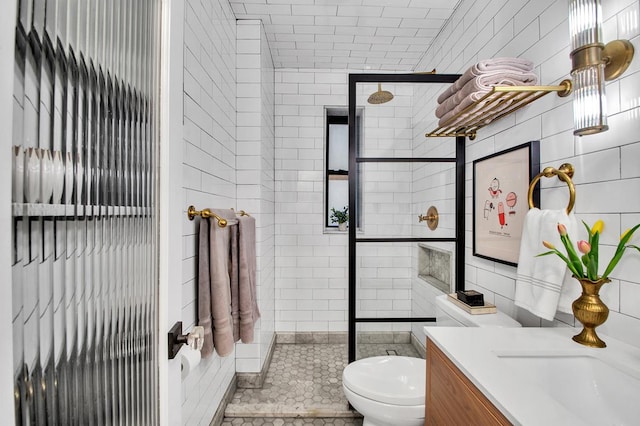 222 E 35th St Unit 1-E, New York City, NY 10016 - bathroom featuring vanity, tiled shower, and tile walls