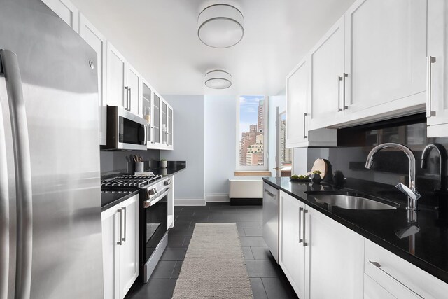 300 E 77th St Unit 10C, New York City, NY 10075 - kitchen with appliances with stainless steel finishes, white cabinets, dark countertops, and glass insert cabinets