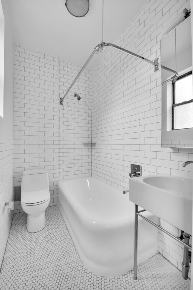253 W 16th St Unit 6D, New York City, NY 10011 - full bathroom featuring tile walls, toilet, shower / washtub combination, and tile patterned flooring