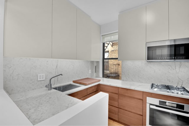 253 W 16th St Unit 6D, New York City, NY 10011 - kitchen with appliances with stainless steel finishes, modern cabinets, and a sink
