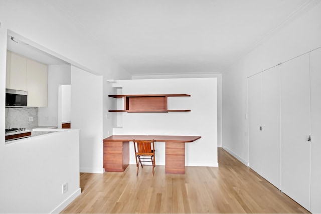 253 W 16th St Unit 6D, New York City, NY 10011 - kitchen featuring stainless steel microwave, open shelves, light wood-style flooring, decorative backsplash, and light countertops