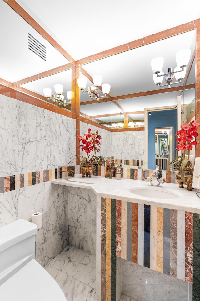 60 E End Ave Unit 27B, New York City, NY 10028 - bathroom featuring a chandelier, marble tiled flooring, and vanity