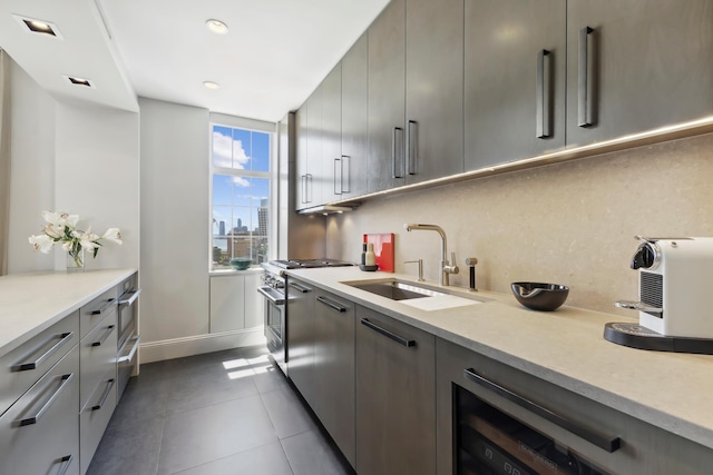 465 W 23rd St Unit 19D, New York City, NY 10011 - kitchen with a sink, high end stove, gray cabinets, dark tile patterned floors, and light countertops