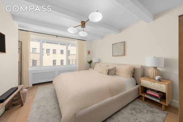 135 E 83rd St Unit 8/9C, New York City, NY 10028 - bedroom with beam ceiling, light wood-style floors, and radiator