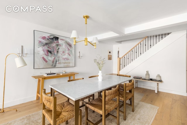 135 E 83rd St Unit 8/9C, New York City, NY 10028 - dining area featuring beam ceiling, a chandelier, light wood-style floors, stairway, and baseboards