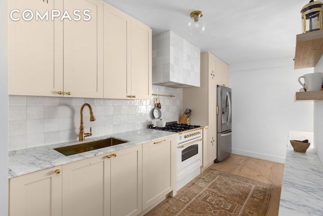 135 E 83rd St Unit 8/9C, New York City, NY 10028 - kitchen featuring stainless steel fridge, a sink, wall chimney range hood, tasteful backsplash, and baseboards