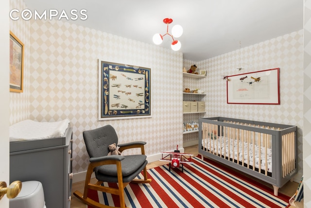 135 E 83rd St Unit 8/9C, New York City, NY 10028 - bedroom with a crib, baseboards, and wallpapered walls
