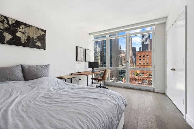 305 E 51st St Unit 20-B, New York City, NY 10022 - bedroom with a wall of windows and wood finished floors