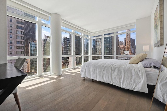 305 E 51st St Unit 20-B, New York City, NY 10022 - bedroom with a view of skyline, a wall of windows, and wood finished floors
