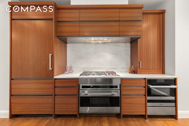150 Charles St Unit 4An, New York City, NY 10014 - kitchen featuring stainless steel appliances, wood finished floors, modern cabinets, light countertops, and baseboards