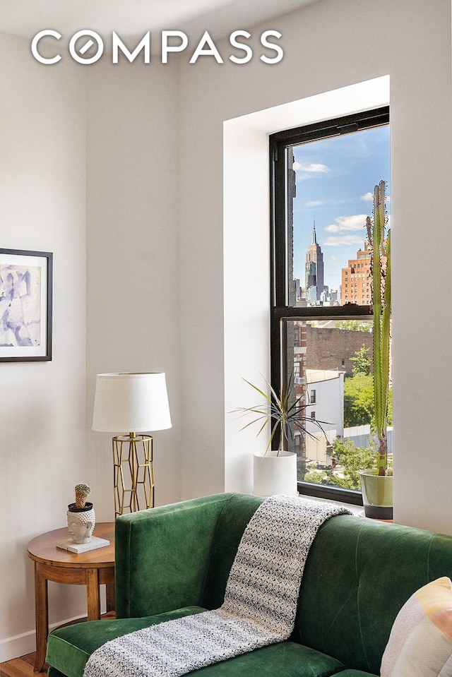 702 E 5th St Unit 5E, New York City, NY 10009 - sitting room featuring a skyline view, wood finished floors, and baseboards
