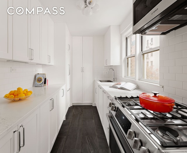 174 E 74th St Unit 3A, New York City, NY 10021 - kitchen with stainless steel range with gas stovetop, a sink, and white cabinetry