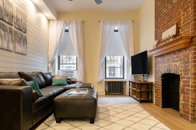 344 E 58th St Unit A, New York City, NY 10022 - living area featuring radiator, light wood finished floors, cooling unit, a fireplace, and ceiling fan