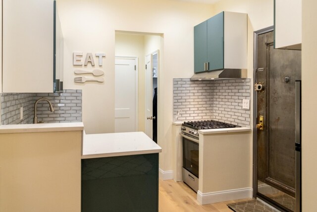 344 E 58th St Unit A, New York City, NY 10022 - kitchen with stainless steel gas range, backsplash, light countertops, and light wood finished floors