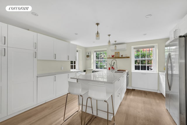 89 State St Unit 1, New York City, NY 11201 - kitchen with freestanding refrigerator, open shelves, light wood-style flooring, white cabinets, and light countertops