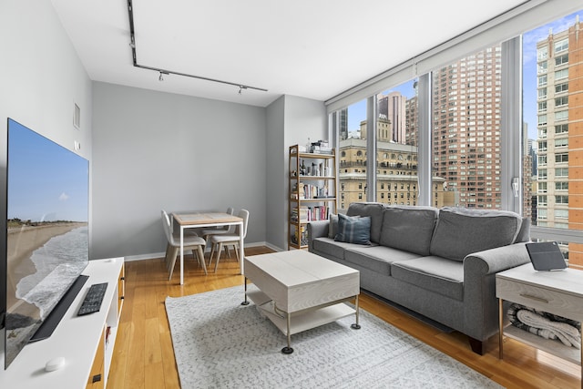 310 W 52nd St Unit 15A, New York City, NY 10019 - living area with a view of city, track lighting, plenty of natural light, and light wood finished floors