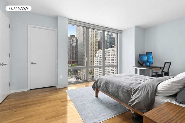 310 W 52nd St Unit 15A, New York City, NY 10019 - bedroom with light wood-style flooring and baseboards