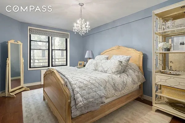 30 E 9th St Unit 2Ii, New York City, NY 10003 - bedroom featuring baseboards, a chandelier, and wood finished floors