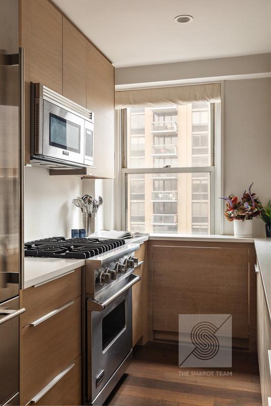 165 W 66th St Unit 21Ef, New York City, NY 10023 - kitchen with appliances with stainless steel finishes, dark wood-style floors, light countertops, modern cabinets, and brown cabinetry