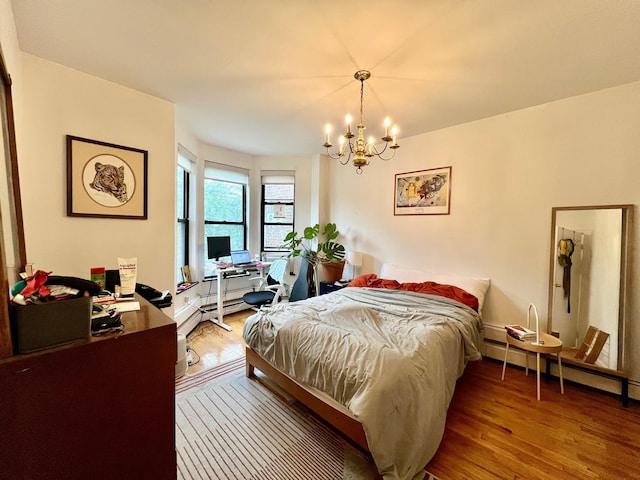 298 12th St Unit 2F, New York City, NY 11215 - bedroom with wood finished floors, a chandelier, a desk, and a baseboard radiator