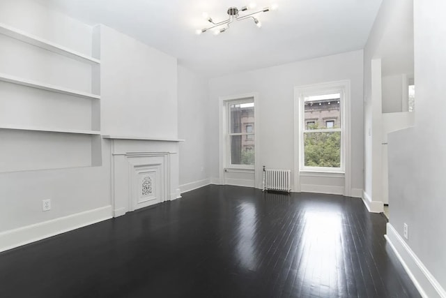 367 Carlton Ave, New York City, NY 11238 - unfurnished living room with radiator, wood-type flooring, and a chandelier