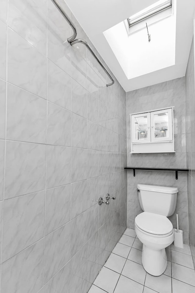 367 Carlton Ave, New York City, NY 11238 - bathroom featuring a skylight, tile patterned floors, and tile walls