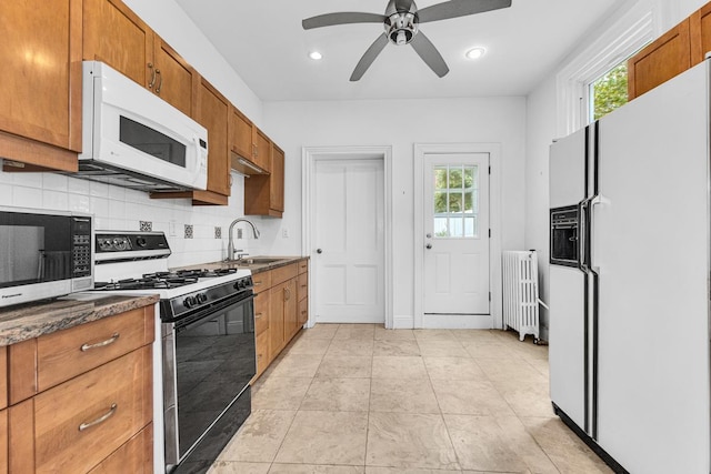 367 Carlton Ave, New York City, NY 11238 - kitchen featuring white appliances, radiator, decorative backsplash, ceiling fan, and brown cabinets