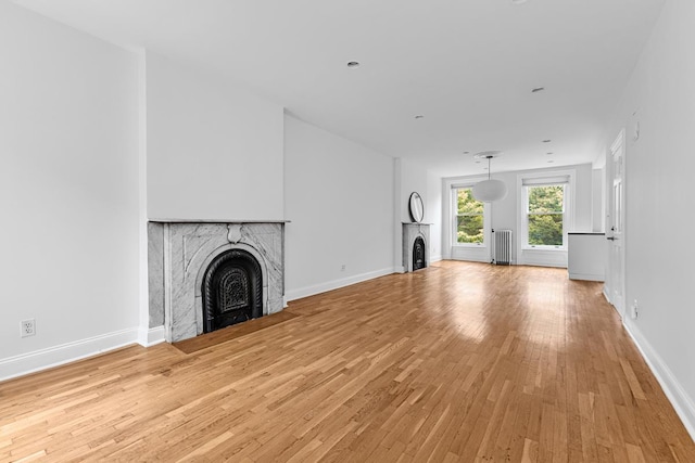 367 Carlton Ave, New York City, NY 11238 - unfurnished living room with a fireplace, radiator heating unit, and light wood-style flooring