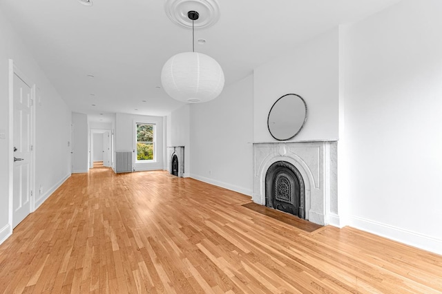 367 Carlton Ave, New York City, NY 11238 - unfurnished living room featuring light wood-type flooring, a fireplace, and radiator heating unit