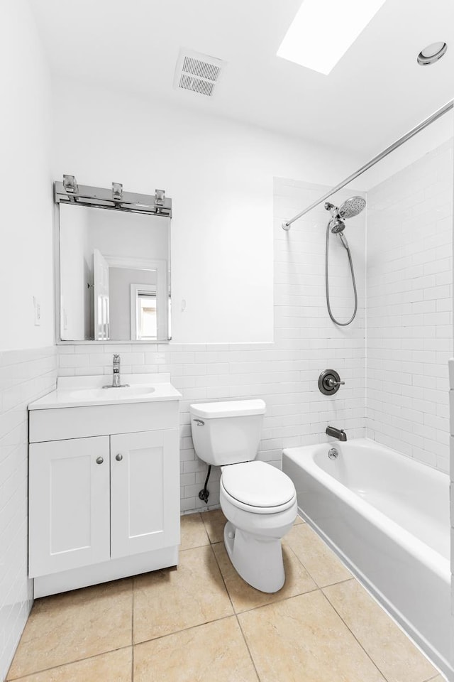 367 Carlton Ave, New York City, NY 11238 - bathroom with vanity, shower / bathtub combination, tile walls, tile patterned flooring, and a wainscoted wall