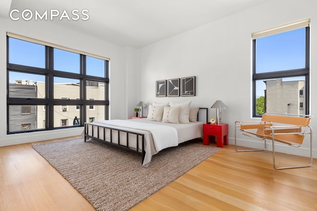868 Lorimer St Unit 3C, New York City, NY 11222 - bedroom with multiple windows, wood finished floors, and baseboards