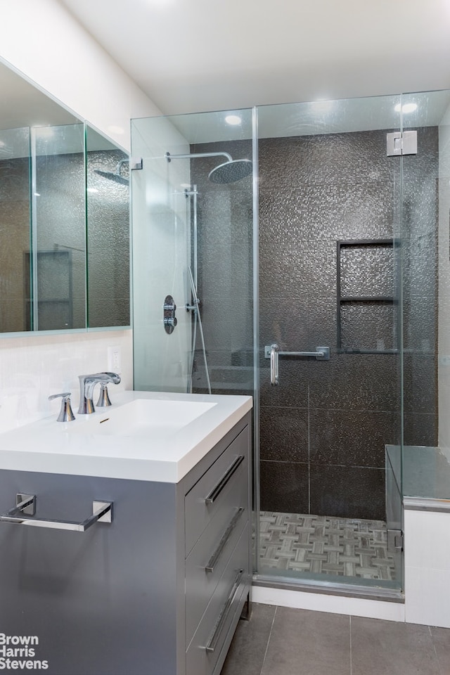 400 E 56th St Unit 27H, New York City, NY 10022 - bathroom featuring vanity, a stall shower, and tile patterned flooring