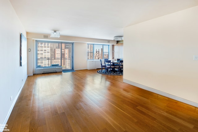 400 E 56th St Unit 27H, New York City, NY 10022 - living room featuring baseboards and wood finished floors