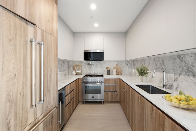 110 Eckford St Garden, Unit Garden, New York City, NY 11222 - kitchen featuring modern cabinets, high end range, a sink, light stone counters, and white cabinets