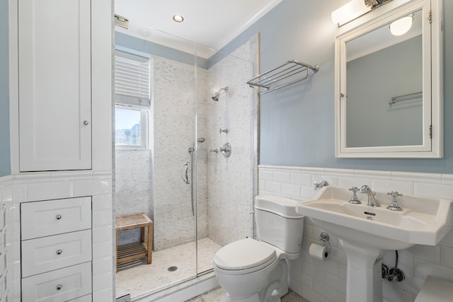 14 E 75th St Unit 10D, New York City, NY 10021 - bathroom with a shower stall, tile walls, toilet, and a wainscoted wall