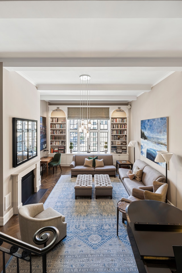 14 E 75th St Unit 10D, New York City, NY 10021 - living area featuring beam ceiling, built in features, ornamental molding, baseboards, and a chandelier