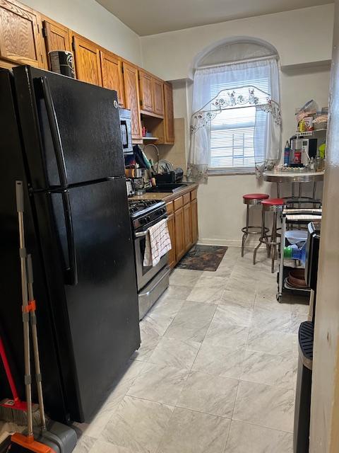 1181 Bushwick Ave, New York City, NY 11221 - kitchen with appliances with stainless steel finishes and brown cabinets