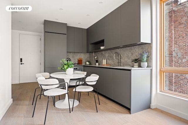 1118 Fulton St Unit 5F, New York City, NY 11238 - kitchen with modern cabinets, gray cabinetry, light wood-type flooring, and tasteful backsplash