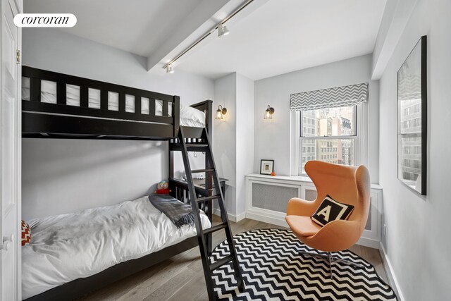 2166 Broadway Unit 7B, New York City, NY 10024 - bedroom with radiator heating unit, wood finished floors, and track lighting