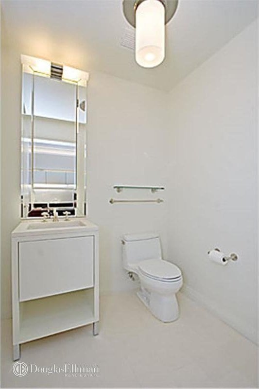 55 Wall St Unit 816, New York City, NY 10005 - bathroom with toilet, vanity, and tile patterned flooring