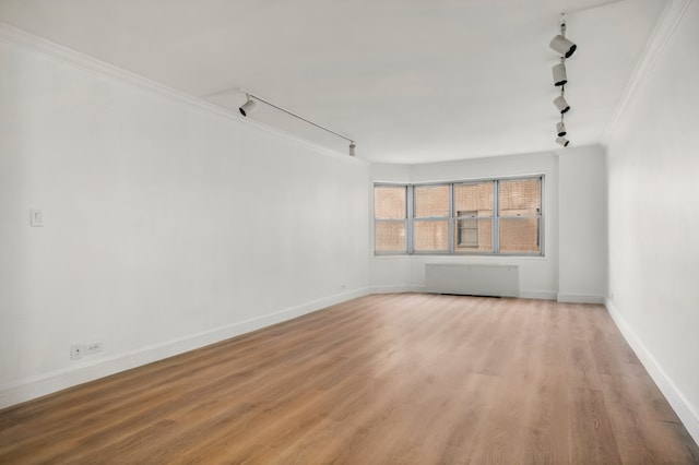 400 E 56th St Unit 31J, New York City, NY 10022 - spare room with rail lighting, crown molding, and light wood-type flooring