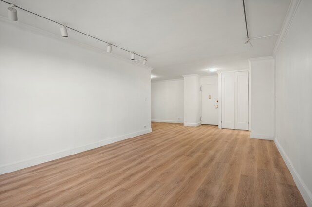 400 E 56th St Unit 31J, New York City, NY 10022 - below grade area featuring light wood-style floors, track lighting, and crown molding