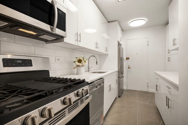 400 E 56th St Unit 31J, New York City, NY 10022 - kitchen featuring stainless steel appliances, backsplash, white cabinets, and light stone counters