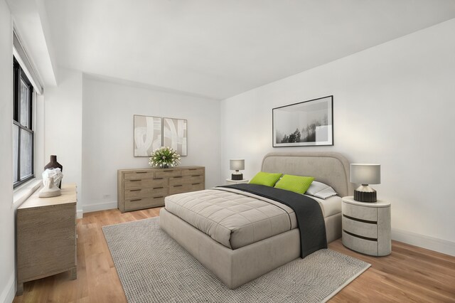 400 E 56th St Unit 31J, New York City, NY 10022 - bedroom featuring baseboards and light wood-style flooring