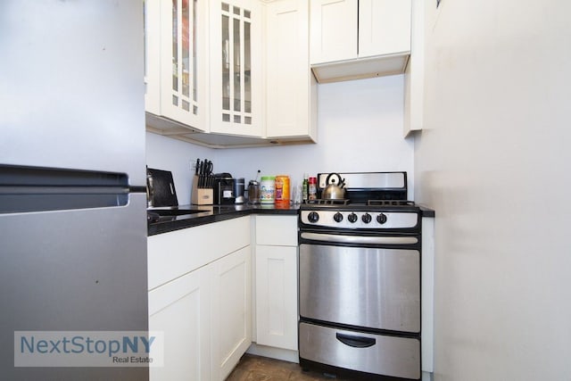 200 E 36th St Unit 11E, New York City, NY 10016 - kitchen with stainless steel appliances, white cabinets, glass insert cabinets, and dark countertops