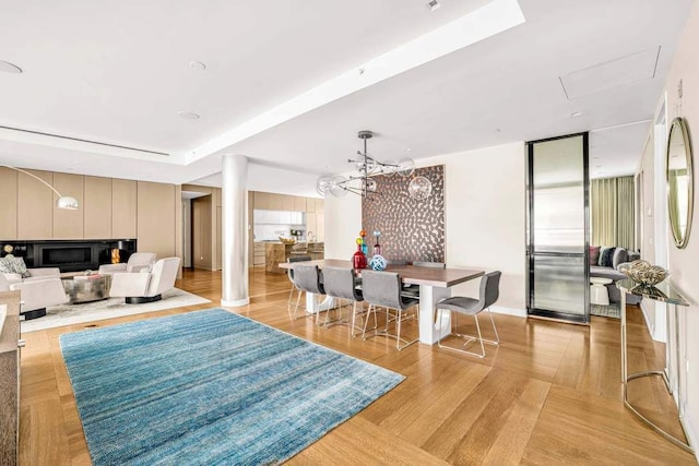 21 W 20th St Unit Ph1, New York City, NY 10011 - dining room featuring a fireplace, light wood-style floors, and a tray ceiling