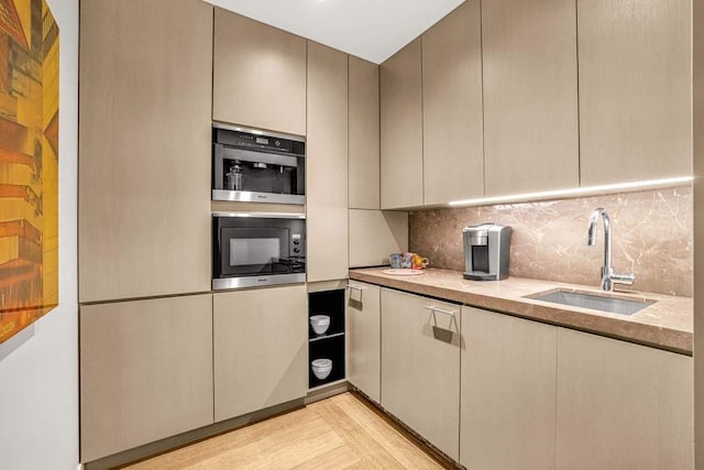 21 W 20th St Unit Ph1, New York City, NY 10011 - kitchen with light wood-style floors, black microwave, tasteful backsplash, light countertops, and modern cabinets