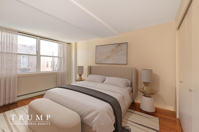 303 W 146th St Unit 7-R, New York City, NY 10039 - bedroom featuring a closet, wood finished floors, and a baseboard heating unit